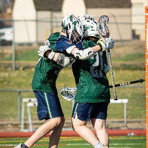 JV lacrosse players celebrate after a goal